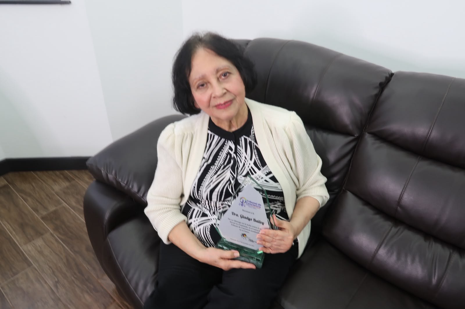 Gladys Bailey sentada con un libro durante la visita